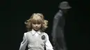 Model kecil ini tampak berjalan diatas catwalk dengan senyum misteriusnya di Moscow Fashion Week (REUTERS/Sergei Karpukhin)