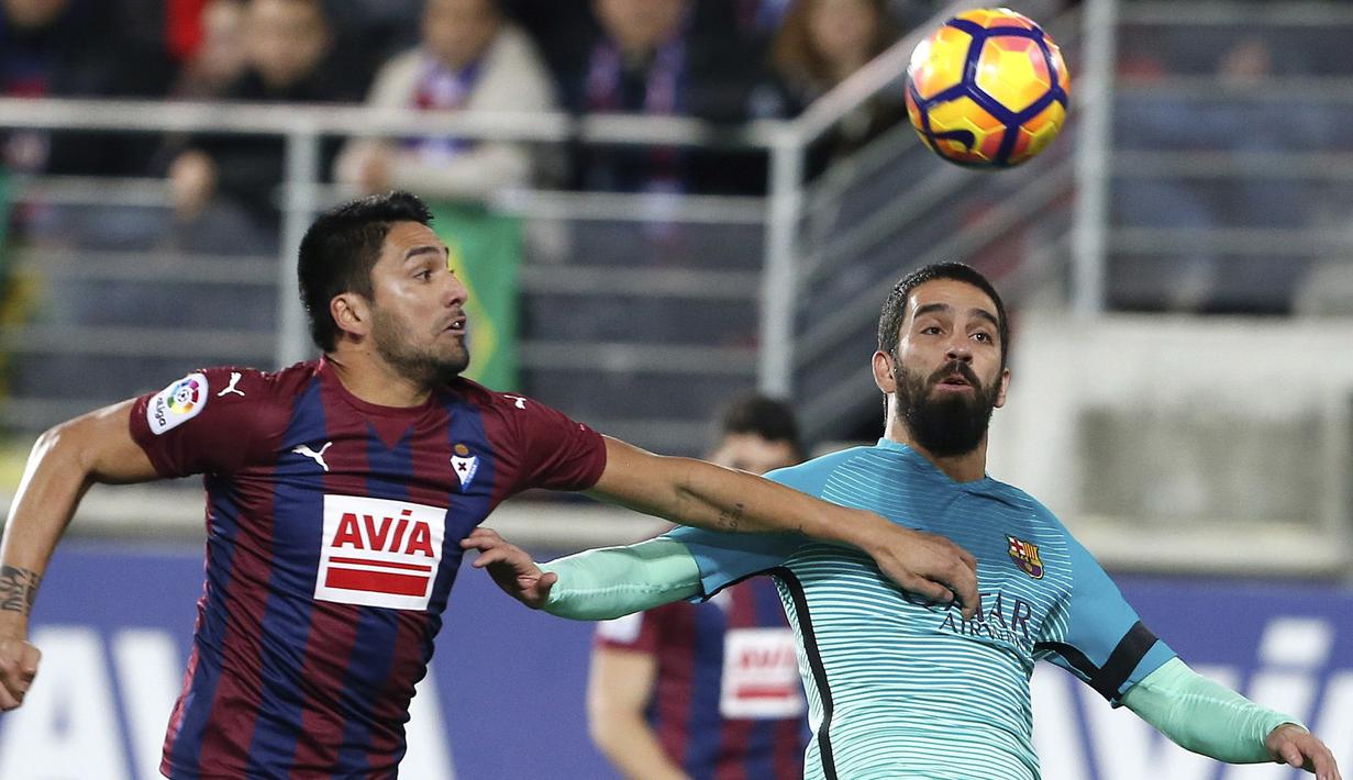 Pemain FC Barcelona, Arda Turan  (kanan) berebut bola dengan pemain Eibar, Mauro dos Santos pada lanjutan La Liga Spanyol di Municipal de Ipurua, Eibar, (22/1/2017). Barcelona menang 4-0. (EPA/Juan Herrero)