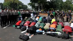 Mahasiswa melaksanakan salat berjamaah disela aksi unjuk rasa di depan Istana Negara, Jakarta, Kamis (21/5/2015).  Aksi tersebut menuntut agar Pemerintahan memprioritaskam masyarakat pribumi daripada asing. (Liputan6.com/Johan Tallo)