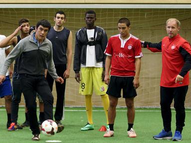 Para imigran mengikuti sesi pelatihan sepak bola di Wina, Austria. Klub asal Austria, FK Austria Wien menyediakan fasilitas bermain sepak bola bagi para pencari suaka yang juga ditujukan untuk pencarian bakat. (Reuters/Heinz-Peter Bader)