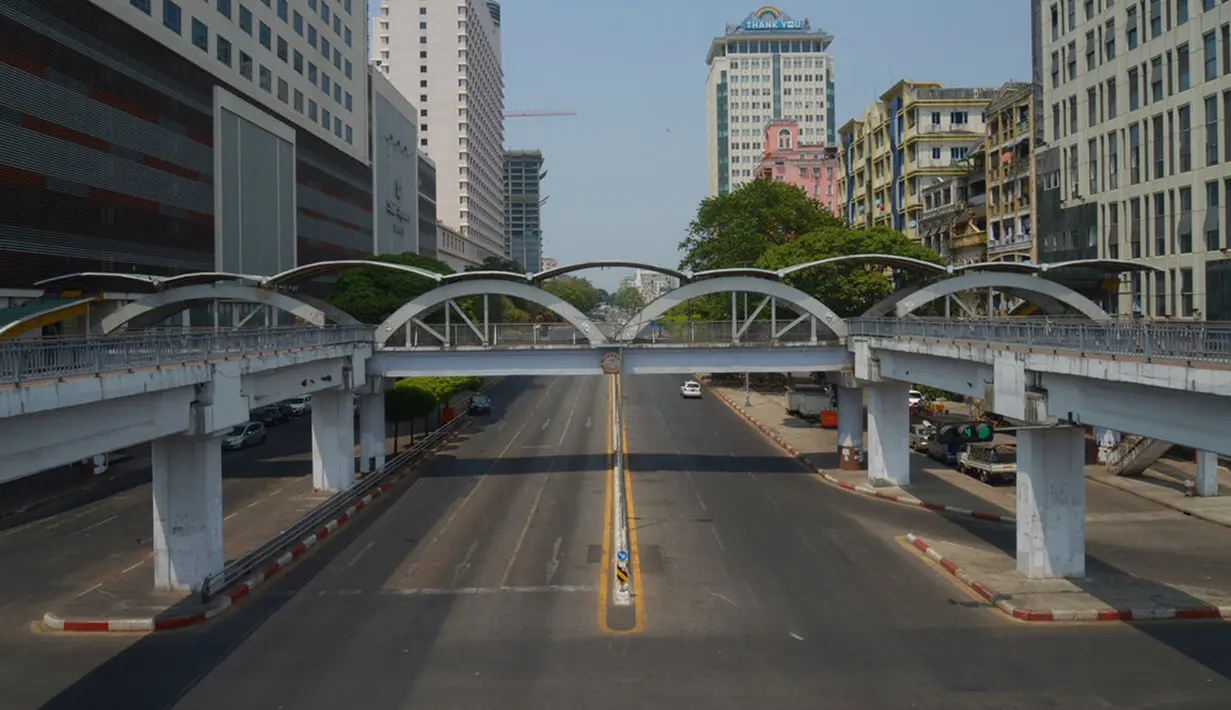 Sebuah mobil melintasi jalanan yang kosong di pusat Kota Yangon, Myanmar, Rabu (24/3/2021. Demonstran antikudeta mencoba taktik baru yang mereka sebut pemogokan 'diam', menyerukan orang-orang untuk tinggal di rumah dan menutup bisnis. (AP Photo)