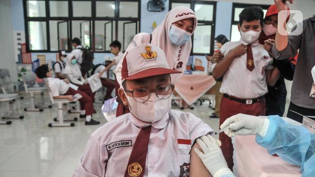 <span>Seorang murid menjalani vaksinasi COVID-19 di SDN Cempaka Putih Timur 03 Pagi, Jakarta, Selasa (14/12/2021). Pemerintah menyiapkan 58 juta dosis vaksin COVID-19 untuk anak usia 6-11 tahun. (merdeka.com/Iqbal S. Nugroho)</span>