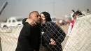 Seorang wanita mencium anaknya diantara pagar pembatas di kamp pengungsian Khazer, Irak(28/11). Banyak pengungsi tak mampu menahan haru saat mereka bisa kembali bertemu dengan keluarganya setelah terpisah lebih dari dua tahun. (Reuters/Mohammed Salem)