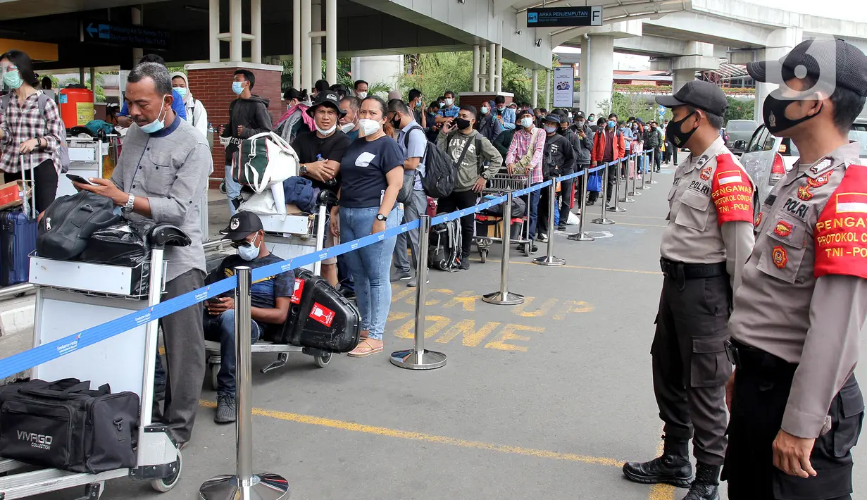 Polisi berjaga saat calon penumpang mengntre untuk rapid test antigen di Terminal 2 Bandara Soekarno-Hatta, Tangerang, Banten, Selasa (22/12/2020). Calon penumpang mengaku rata-rata antre hingga tiga jam untuk mendapatkan layanan rapid test antigen. (merdeka.com/Arie Basuki)