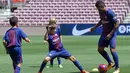 Gelandang baru Barcelona, Paulinho bermain bola dengan anak-anak saat perkenalan dirinya di Stadion Nou Camp, Barcelona, (17/8). Paulinho meneken kontrak empat musim di Camp Nou. (AFP Photo/Lluis Gene)