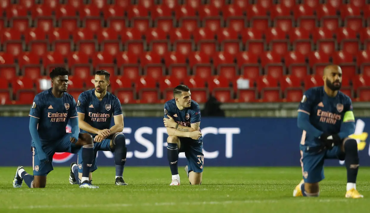 Sebelum kick-off berlangsung, Alexandre Lacazette yang ditunjuk sebagai kapten memimpin rekan-rekannya untuk berlutut di depan dengan para pemain Slavia Praha. (AP Photo/Petr David Josek)