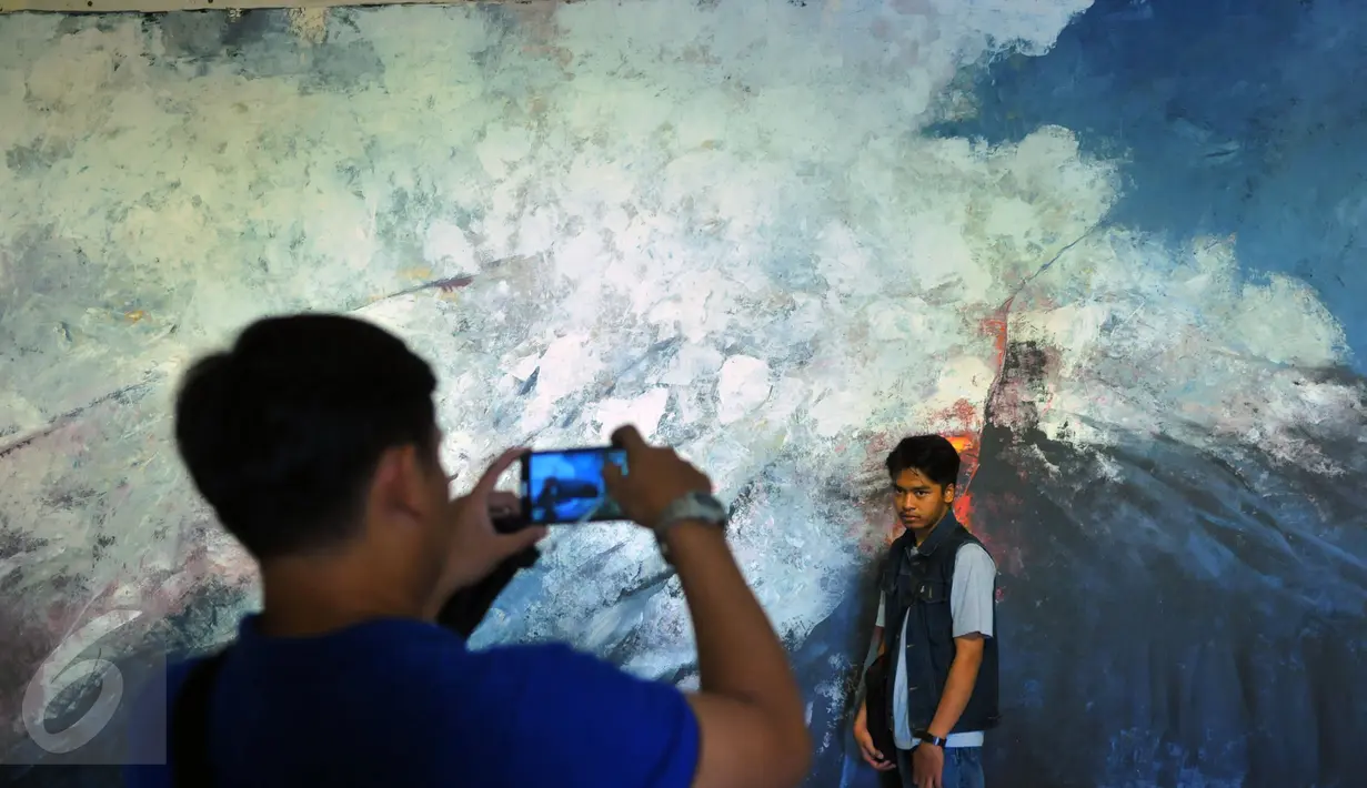 Pengunjung berfoto di salah satu lukisan yang berada di pameran “Pintu Belakang | Derau Jawa" di Galeri Nasional Indonesia, Jakarta (12/3). Pameran ini hasil karya Hanafi yang berasal dari Jawa. (Liputan6.com/Faisal R Syam)
