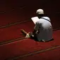Seorang umat muslim membaca Al Quran di masjid Istiqlal Jakarta, Senin (27/6). 10 hari jelang akhir Ramadan, sejumlah umat muslim dari berbagai daerah melakukan itikaf di masjid Istiqlal Jakarta. (Liputan6.com/Helmi Fithriansyah) 