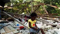 Seorang anak bermain di dekat rumahnya yang ambruk akibat guncangan gempa berkekuatan 7,1 SR di Kampung Kainui I, Distrik Angkaisera, Kepulauan Yapen, Papua, Jumat (25/6).(Antara) 
