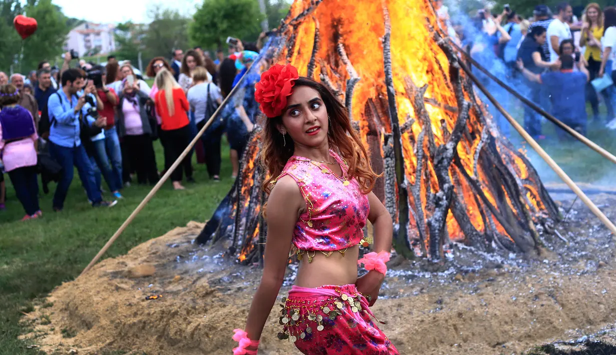 Seorang wanita menari di sekitar api unggun saat Festival Hidirellez di Edirne, Turki, Jumat (5/5). Festival Hidirellez menandai kembalinya musim semi sambil menari, api unggun dan mandi di Sungai Tundzha. (AP Photo / Lefteris Pitarakis)