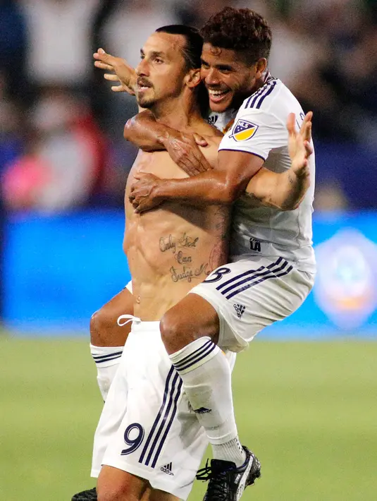 Penyerang LA Galaxy, Zlatan Ibrahimovic berselebrasi bersama rekannya Jonathan Dos Santos usai mencetak gol ketiga ke gawang Orlando City pada pertandingan MLS di StubHub Center di Carson, California (29/7). (AFP Photo/Katharine Lotze)