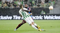Pemain Trabzonspor, Stefano Denswil, berusaha menghadang pergerakan pemain Ferencvaros, Kristoffer Zachariassen, pada laga Liga Europa di  Groupama Arena, Jumat (9/9/2022). (Tamas Kovacs/MTI via AP)