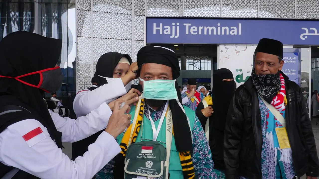 Petugas Jemaah haji memberikan anjuran agar jemaah selalu memakai alat perlindungan diri. Foto: Darmawan/MCH