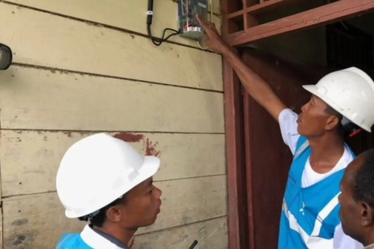 Petugas PLN memasang listrik di rumah warga di Desa Parauto, Nabire, Papua. (Vina A. Muliana/Liputan6.com)