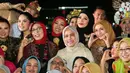 Bukan tas branded, kali ini ibu tiga anak itu melengkapi penampilannya dengan tas etnik rotan yang unik.