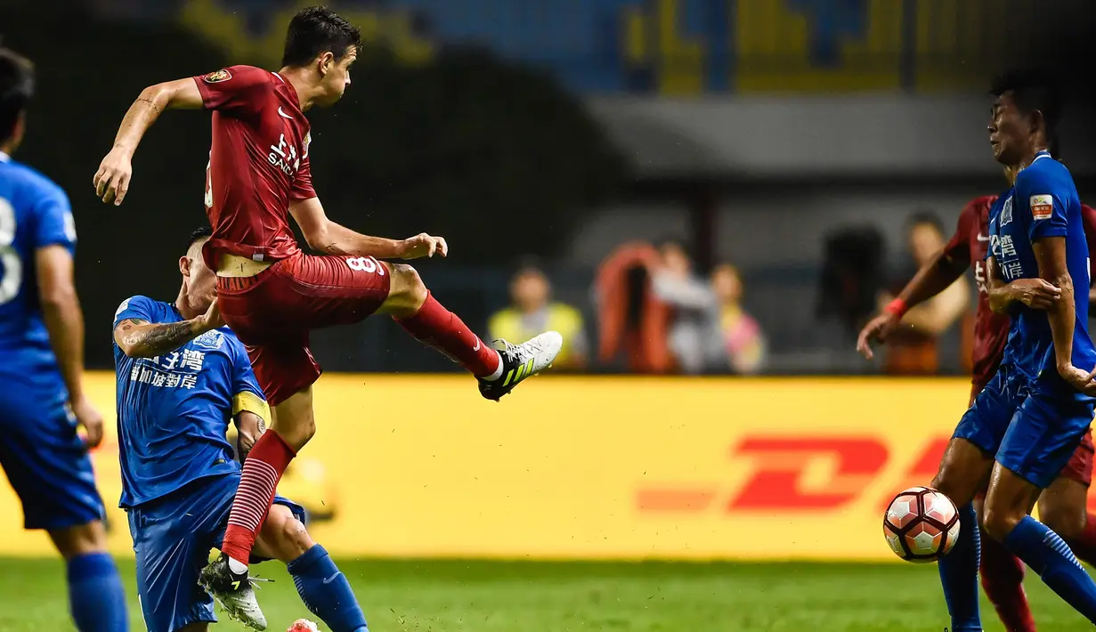 Gelandang Shanghai SIPG, Oscar saat menendang bola ke arah pemain Guangzhou R&F pada pertandingan Liga Super China di Guangzhou, Guangdong, China, (18/6). Akibat pertandingan ini, satu pemain dari kedua tim terkena kartu merah. (AFP Photo/Str/China Out)