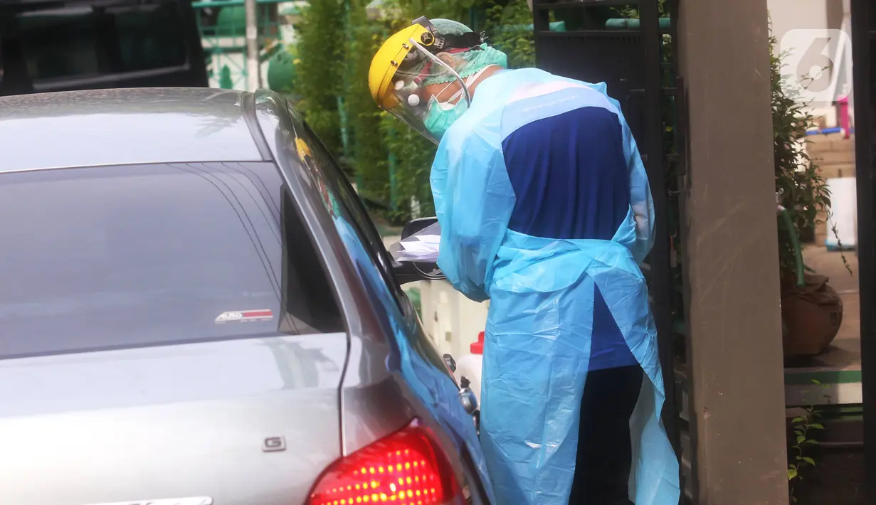 Petugas mengambil sampel spesimen saat swab test secara drive thru di halaman Laboratorium Kesehataan Daerah (LABKESDA) Kota Tangerang, Banten, Kamis (9/4/2020). Pemkot Tangerang melaksanakan swab test yang dilakukan untuk tenaga medis dan orang dalam pemantauan (ODP). (Liputan6.com/Angga Yuniar)