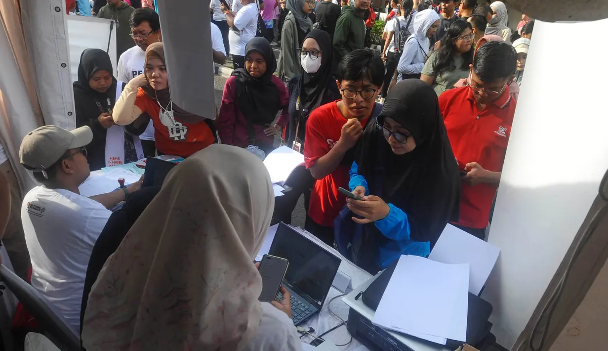 Warga antri melakukan pengurusan surat pindah Tempat Pemungutan Suara (TPS) pada Pemilu 2024 di salah satu gerai yang disediakan Komisi Pemilihan Umum (KPU) di kawasan Bundaran Hotel Indonesia, Jakarta, Minggu (14/1/2023). (merdeka.com/Arie Basuki)