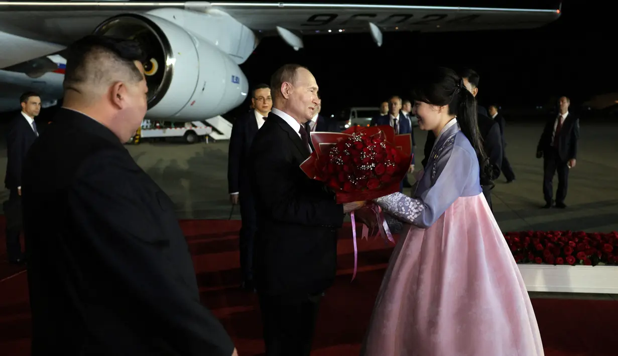Setelah itu, Putin diberikan sebuket bunga oleh gadis yang mengenakan pakaian nasional hanbok. (Gavriil GRIGOROV / POOL / AFP)