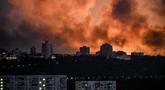 Asap mengepul saat cahaya dari api menerangi langit selama serangan Rusia di ibu kota Ukraina, Kyiv, pada Minggu 24 Mei 2026, di tengah invasi Rusia di Ukraina. (Evgen KOTENKO/AFP)