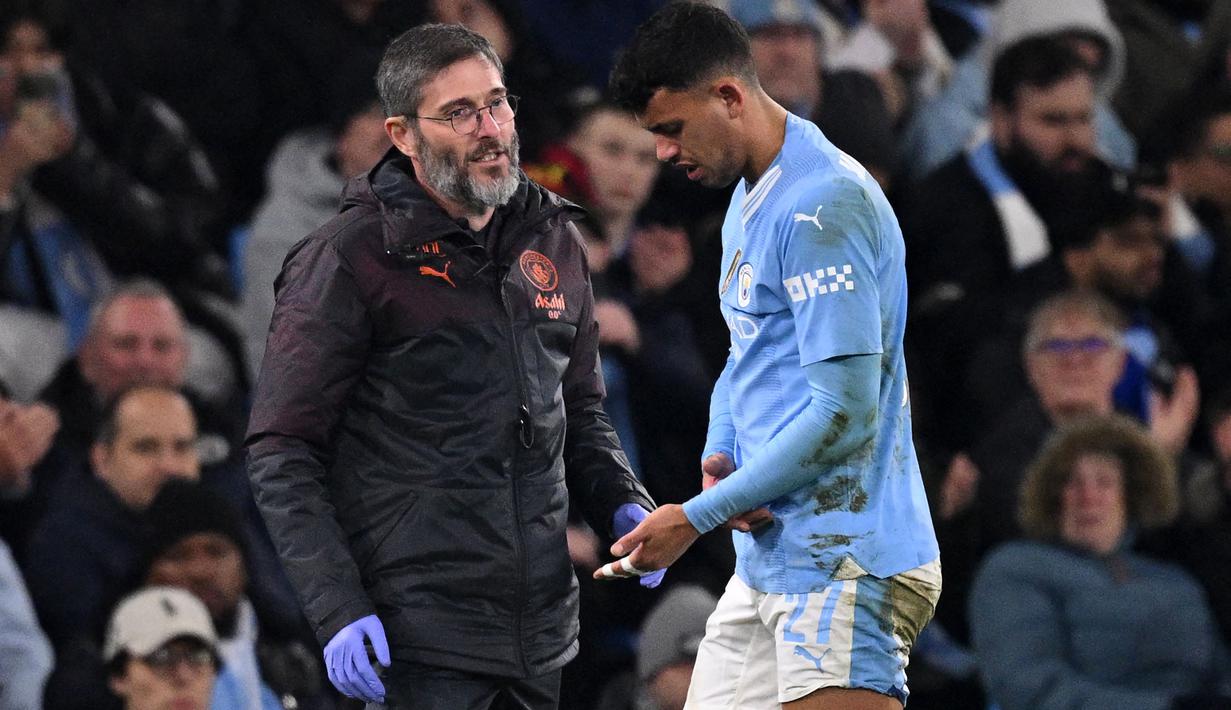 Pemain Manchester City, Matheus Nunes meninggalkan lapangan pertandingan setelah mengalami dislokasi pada jari tengah tangan kirinya ketika laga leg kedua 16 besar Liga Champions 2023/2024 melawan FC Copenhagen di Etihad Stadium, Manchester, Inggris, Kamis (07/03/2024) WIB. (AFP/Oli Scarff)