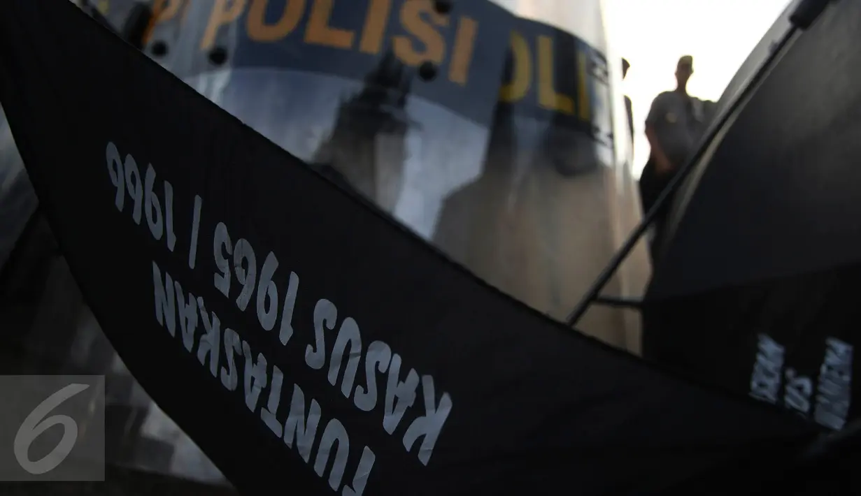 Polisi berjaga di lokasi aksi Kamisan ke-438 di seberang Istana Merdeka, Jakarta, Kamis (7/4). Mereka berharap agar Presiden Jokowi memegang teguh komitmen untuk menyelesaikan pelanggaran HAM berat masa lalu. (Liputan6.com/Immanuel Antonius)