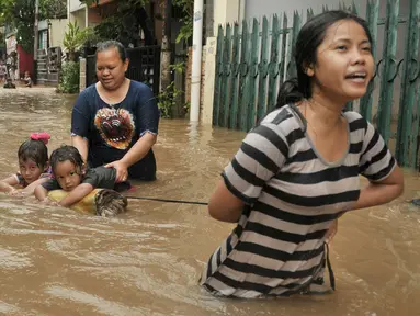 Warga melintasi banjir di kawasan Cipinang Melayu, Jakarta Timur, Senin (20/2). Banjir ini merendam RW 3 hingga RW 4, Kelurahan Cipinang Melayu, Kecamatan Cipinang Muara. (Liputan6.com/Yoppy Renato)
