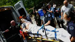 Seorang pemuda korban ledakan di Central Park, New York, dimasukkan ke dalam ambulans, Minggu (3/7). Belum diketahui penyebab ledakan itu, tapi ada dugaan ledakan disebabkan oleh kembang api menjelang Hari Kemerdekaan pada Senin (4/7). (Kena Betancur/AFP)