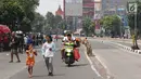 Pengendara motor melintasi arena Car Free Day (CFD) di Jalan Warung Jati Barat, Jakarta, Minggu (17/9).  Beberapa pengendara motor terlihat bebas menerabas jalan yang dipenuhi orang yang sedang berolahraga dan berjualan. (Liputan6.com/Immanuel Antonius)