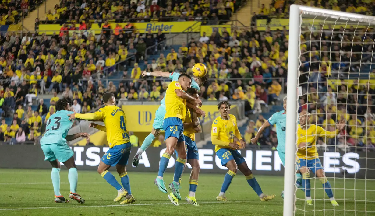 Pemain Barcelona, Robert Lewandowski, duel udara dengan pemain Las Palmas, Sergi Cardona, pada laga La Liga 2023/2024 jornada 19 di Estadio de Gran Canaria, Jumat (5/1/2024). (AFP/Desiree Martin)