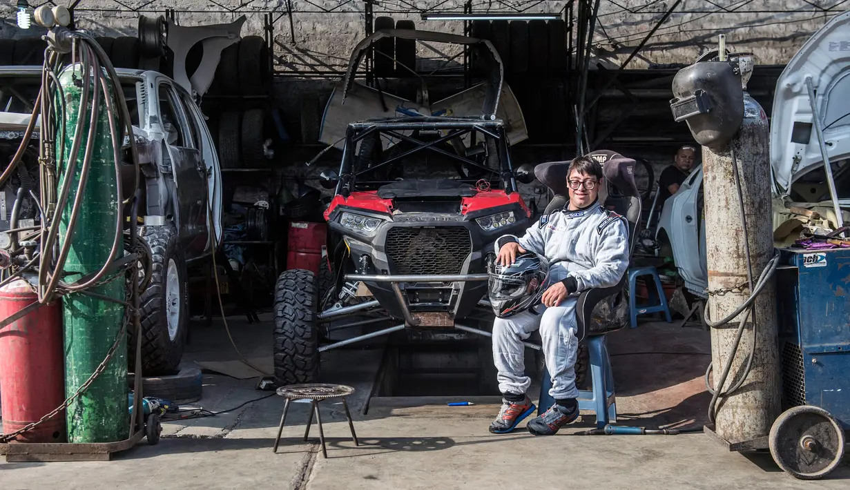 Paralympian Peru, Lucas Barron berpose dekat mobil untuk Rally Dakar 2019 di Lima, 18 Desember 2018. Baron akan membuat sejarah sebagai pereli dengan down syndrome pertama selama 40 tahun penyelenggaraan Dakar Rally. (ERNESTO BENAVIDES /AFP)