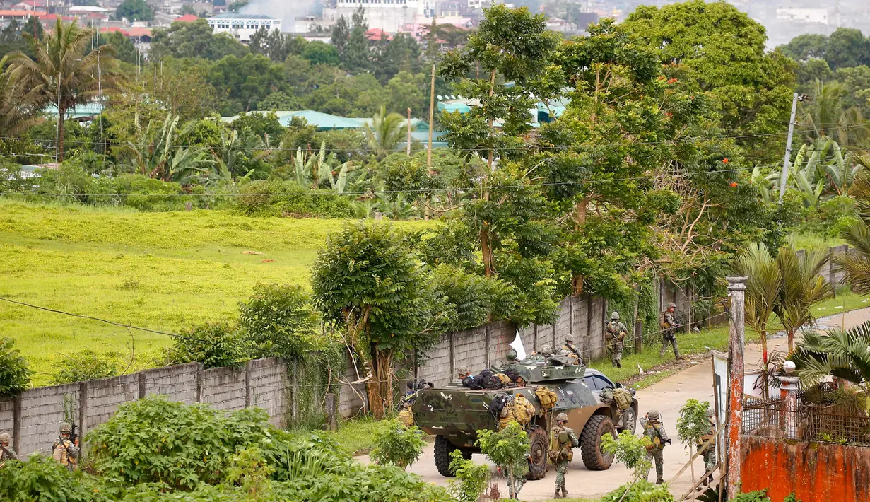 Sejumlah tentara pemerintah mengambil posisi saat memerangi kelompok Maute di Kota Marawi, Filipina, (28/5). Pasukan Filipina melancarkan serangan udara pada hari Minggu untuk mengusir militan yang terkait dengan kelompok ISIS. (AP Photo/Bullit Marquez)