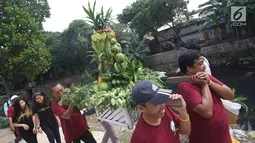 Sejumlah orang mengarak buah-buahan saat pawai keliling dalam acara bertajuk Kampung Jogo Kali di kawasan Lodan, Jakarta Utara, Minggu (12/11). Acara Hari Ciliwung ke-6 ini diisi oleh berbagai kegiatan. (Liputan6.com/Immanuel Antonius)