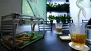 Seekor ular dan minuman ada di atas meja di sebuah kafe ular 'Tokyo Snake Center' di distrik fashion Harajuku, Tokyo, 14 Agustus 2015. Di kafe ini, pengunjung bisa menikmati aneka hidangan lezat sambil ditemani ular-ular nan eksotis. (REUTERS/Toru Hanai)