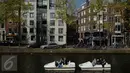 Warga menaiki perahu saat melintasi kanal di kawasan Amsterdam, Belanda (April 2017). Meskipun pada abad ke-19 kotor dan dipenuhi limbah, kini kanal-kanal di Belanda menjadi salah satu objek wisata terkenal di dunia. (Liputan6.com/Immanuel Antonius)