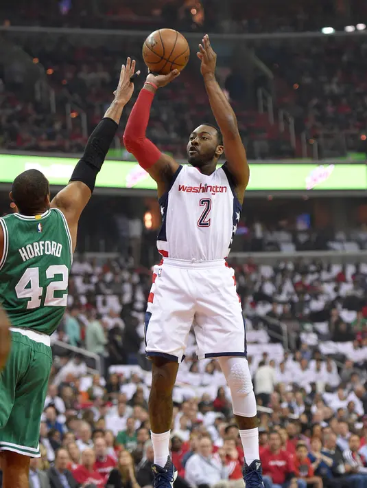 Pemain Wizards, John Wall (2) bersiap menembak bola ke dalam ring dari kawalan pemain Boston Celtics, Al Horford di gim keenam semifinal wilayah timur Playoffs NBA 2017 di Washington (12/5). (AP Photo/Nick Wass)