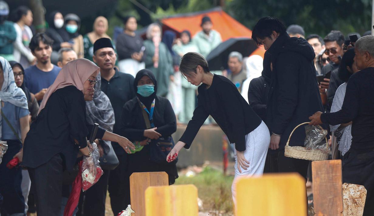 Prosesi pemakaman Vidi Aldiano dihiasi dengan warna biru dari pihak keluarga dan sahabat sebagai bentuk penghormatan khusus bagi almarhum. Tampak dalam foto, Putri YouTuber Deddy Corbuzier, Nada Tarina Putri, menabur bunga di sisi makam Oxavia Aldiano atau lebih dikenal dengan nama Vidi Aldiano di Tempat Pemakaman Umum (TPU) Tanah Kusir, Jakarta, Minggu (8/3/2026). (Kapanlagi.com/Budy Santoso)