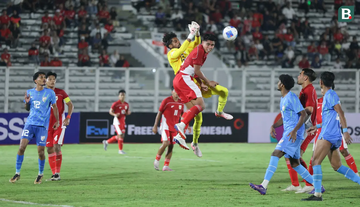 Bek Timnas Indonesia U-22, Muhammad Ferrari, duel udara dengan kiper India pada Laga uji coba di Stadion Madya, Jakarta, Jumat (10/10/2025). (Bola.com/M Iqbal Ichsan)