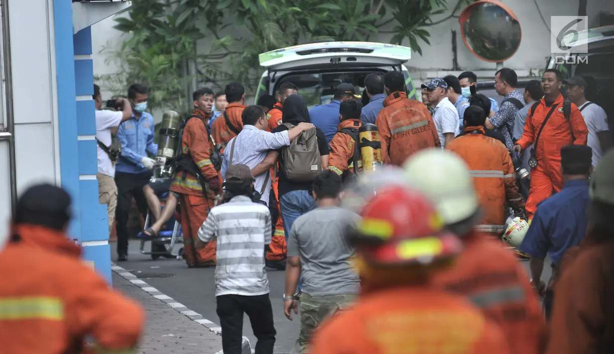 Petugas pemadam mengevakuasi korban selamat ke mobil ambulans di lokasi kebakaran Gedung Kemenhub, Jakarta, Minggu (8/7). Sampai saat ini Sudin Pemadam Kebakaran Jakpus  mencatat ada 20 korban selamat dalam kebakaran. (Merdeka.com/Iqbal S Nugroho)