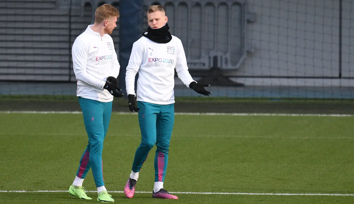 Gelandang Manchester City Kevin De Bruyne (kiri) berbicara dengan Oleksandr Zinchenko (kanan) saat menghadiri sesi latihan tim di City Football Academy di Manchester, barat laut Inggris (8/3/2022). City akan bertanding melawan Sporting CP pada babak 16 besar Liga Champions. (AFP/Oli Scarff)