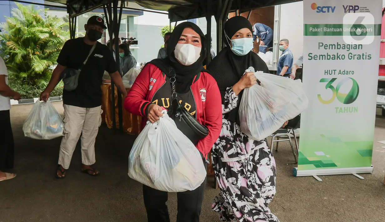 Warga seusai mengambil paket sembako di di Studio 5 Indosiar, Jakarta Barat, Rabu (19/10/20). Dalam rangka HUT ke-30, PT Adaro bekerja sama dengan Yayasan Pundi Amal Peduli Kasih (YPP), Indosiar dan SCTV memberikan 30.000 paket sembako kepada masyarakat seluruh Indonesia. (Liputan6.com/Angga Yuniar)