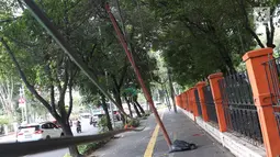 Kondisi tiang yang miring di Jalan Gedung Kesenian, Jakarta, Jumat (22/2). Keberadaan tiang miring tersebut membahayakan keselamatan pejalan kaki karena kabel yang turut menjuntai hingga ke bawah. (Liputan6.com/Immanuel Antonius)