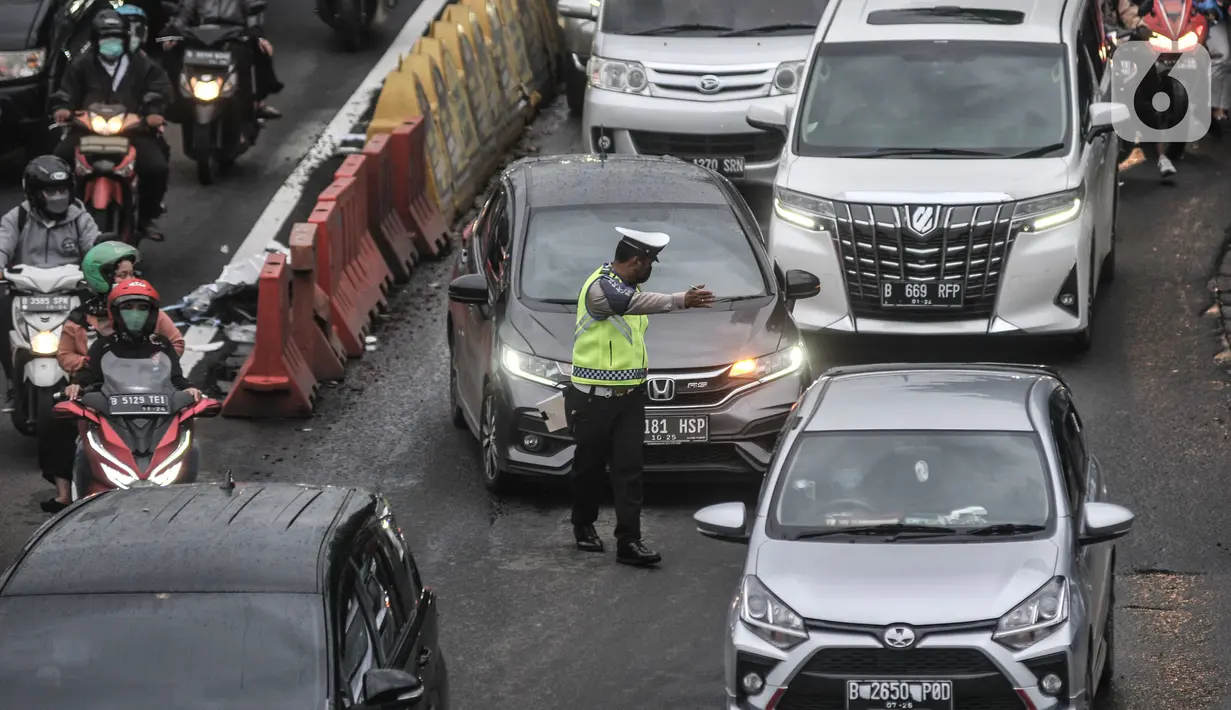 Petugas kepolisian memberhentikan mobil yang melanggar aturan ganjil genap di Jalan MT Haryono, Jakarta, Kamis (28/10/2021). Para pelanggar sistem ganjil genap dikenakan sanksi tilang berupa denda maksimal Rp500 ribu. (merdeka.com/Iqbal S Nugroho)
