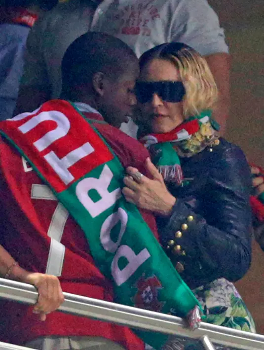 Penyanyi AS, Madonna berbincang dengan anaknya David Banda menyaksikan pertandingan kualifikasi Piala Dunia 2018 antara Portugal dan Swiss di Stadion Luz di Lisbon (10/10). Portugal menang 2-0 atas Swiss. (AFP Photo/Francisco Leong)