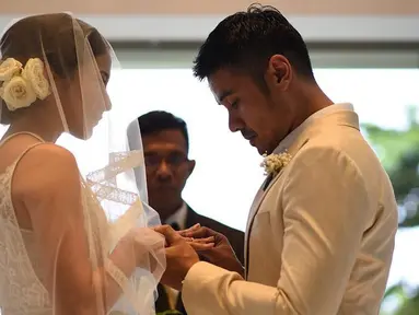 Aktor Chicco Jerikho memakaikan cincin kepada Putri Marino saat acara pernikahannya di Bali. Disaksikan keluarga dan sahabat, pernikahan tersebut berjalan dengan penuh kebahagiaan. (Instagram.com/chicco.jerikho)