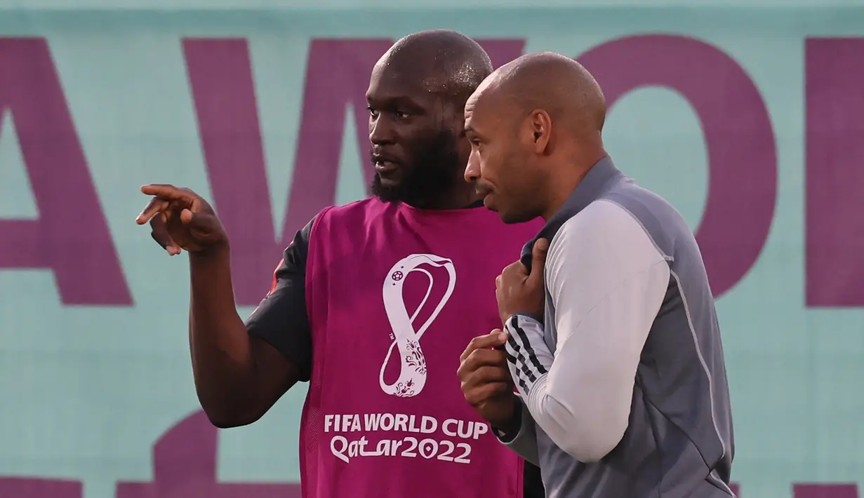 Penyerang Belgia, Romelu Lukaku (Kiri) berbicara dengan asisten pelatih Prancis Belgia Thierry Henry selama sesi latihan di Salwa Training Site di Pantai Salwa, Doha pada 30 November 2022. Di grup ini, dua tiket 16 besar dari Grup F masih diperebutkan oleh tiga tim:  Kroasia, Maroko, dan Belgia. (AFP/Jack Guez)