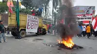 Massa aksi demo membakar ban di depan kantor Balai Kota dan DPRD Kota Balikpapan. (Liputan6.com)