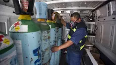 Petugas kesehatan Jose Antonio Pena mengisi ulang tangki oksigen untuk pasien COVID-19 di Distrik Iztapalapa, Mexico City, Meksiko, Selasa (26/1/2021). Mexico City menawarkan isi ulang oksigen gratis untuk pasien COVID-19. (AP Photo/Marco Ugarte)
