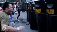 Mahasiswa menyerang polisi yang berjaga saat unjuk rasa di Jalan Medan Merdeka Barat, Jakarta, Kamis (20/10). Mahasiswa menagih janji Nawacita pemerintahan Jokowi-JK. (Liputan6.com/Gempur M Surya)