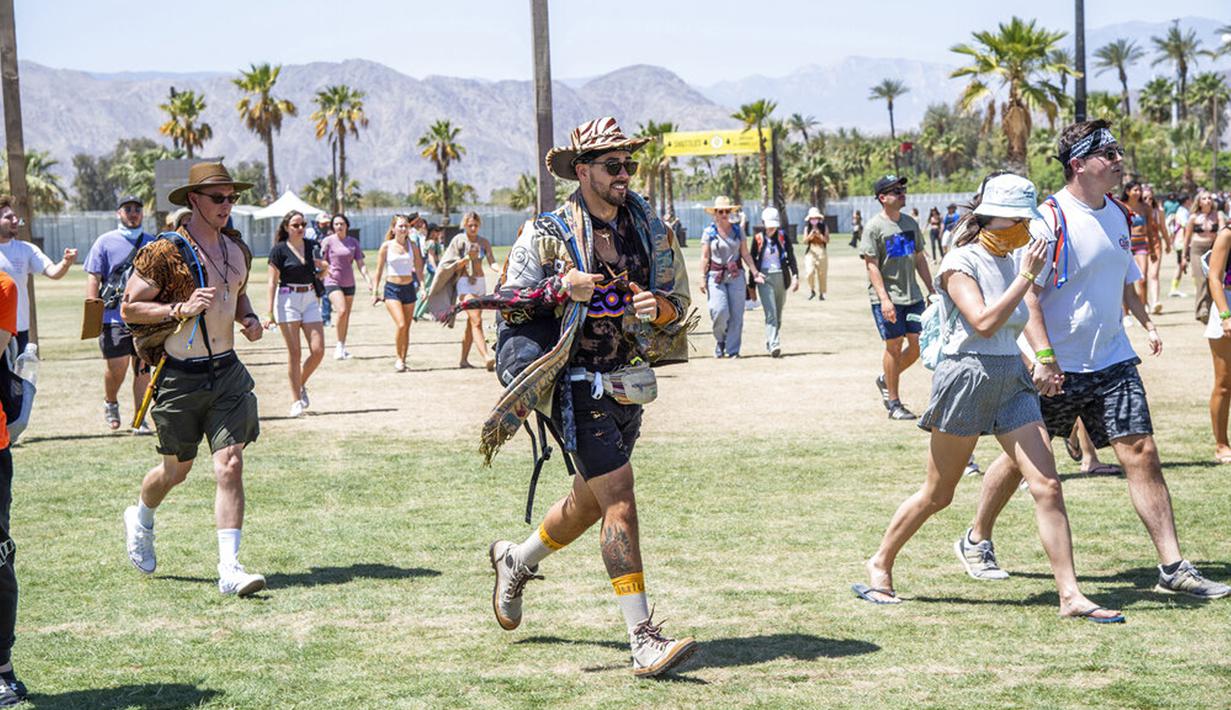 Pengunjung berlarian menuju tenda merchandise di Coachella Music and Arts Festival, Empire Polo Club, Indio, California, Amerika Serikat, 16 April 2022. Niki Zefanya dan Rich Brian menjadi musisi Indonesia pertama yang tampil di Coachella. (Photo by Amy Harris/Invision/AP)